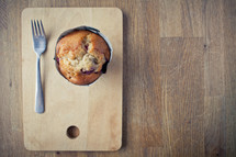a muffin and a fork on a plate 