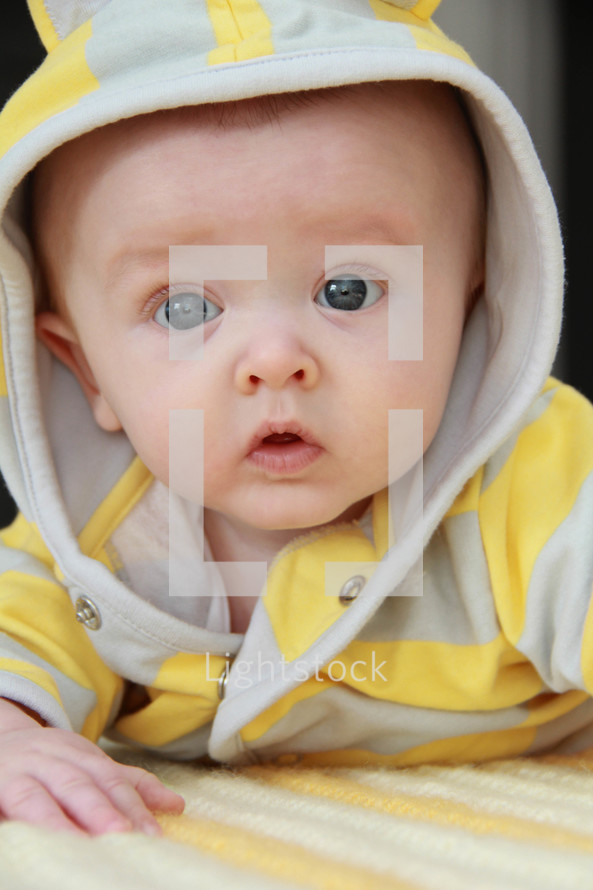 face of an infant boy in a hoodie 