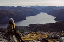 woman looking out at a fjord below 