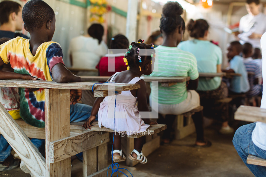 children sitting in desks in a classroom in Haiti