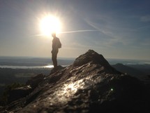 silhouette of a man on top of a mountain 