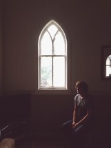 man sitting in a church by a window