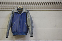 letterman jacket hanging in a locker room 