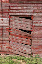 broken door on an old red barn