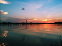 smoke stack and a lake at sunset 