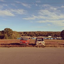 old trucks and storage trailers in a rural setting