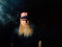 man with a long beard and smoke 