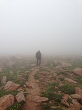 man walking through thick fog 