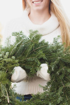 woman holding a Christmas wreath 