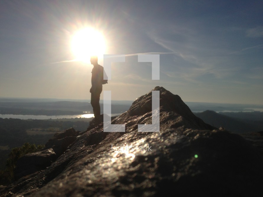 silhouette of a man on top of a mountain 