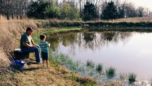 father and son fishing by a lake 