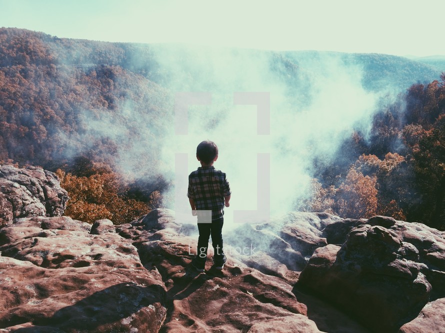 a young boy watching the fog 
