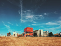 A view of multi-storied buildings  from a field.