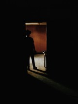 silhouette of a man standing in a doorway