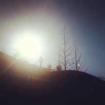 sunburst and a man on a hill