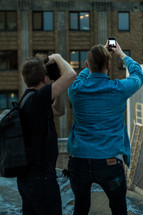 Two men taking pictures.