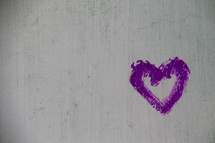 Purple painted heart on a concrete wall
