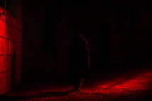 hooded man in red light 