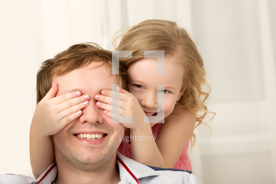 Daughter playing with father closing his eyes