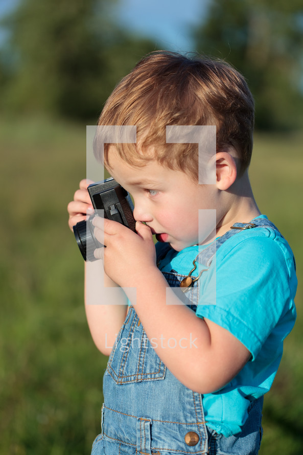 Little child taking pictures outdoor