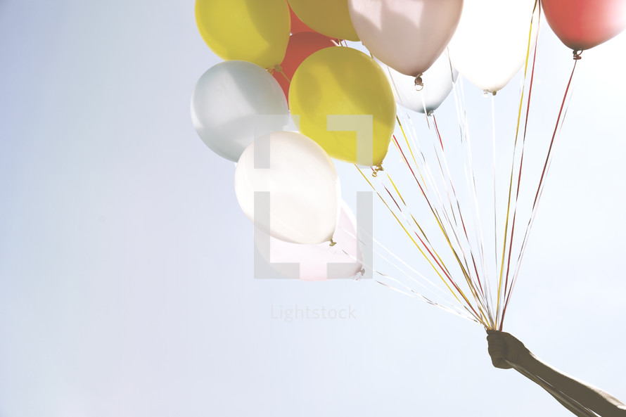 arm holding up balloons 