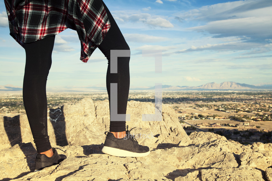 legs of a woman standing on a cliff 