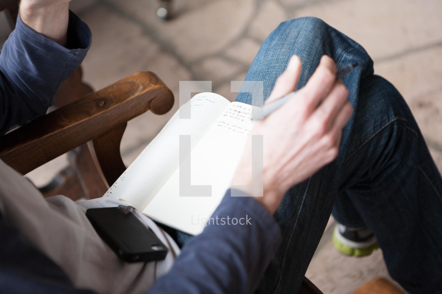 a student sitting with a notebook in his lap 