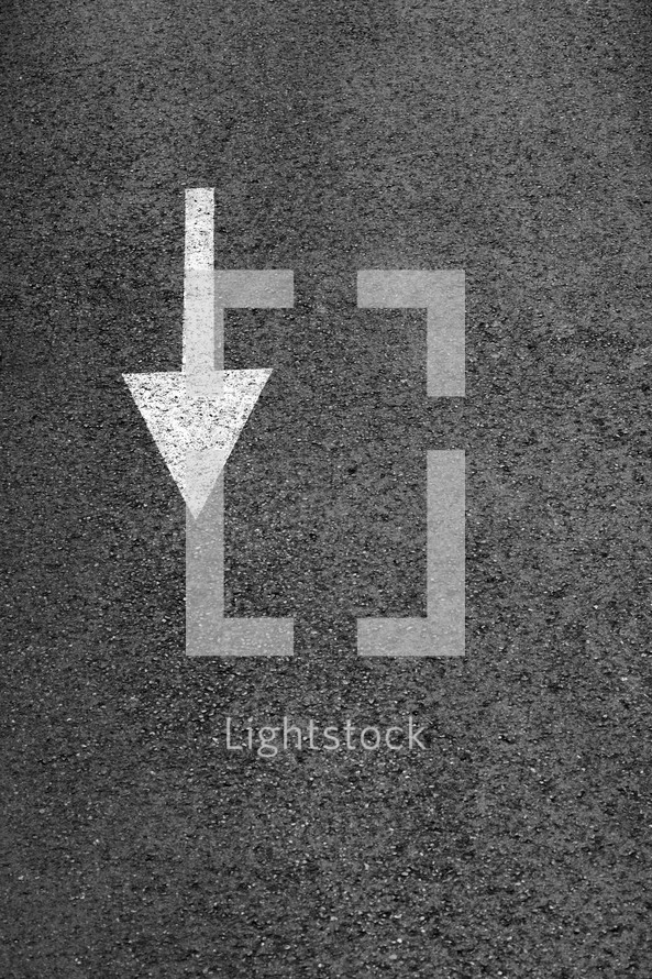 White arrow on the dark gray asphalt