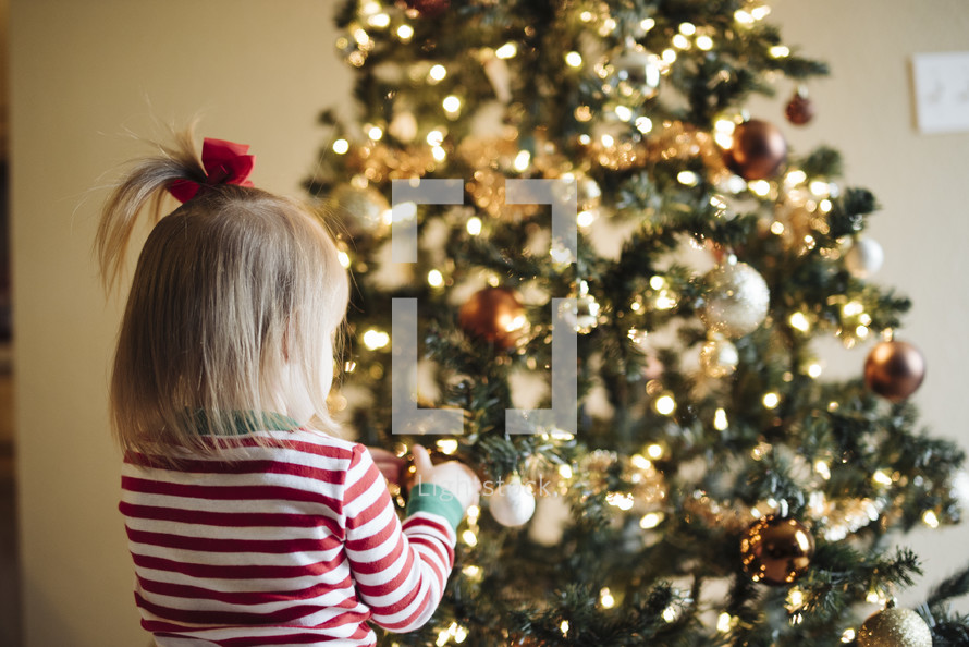 toddler girl in front of a Christmas tree 