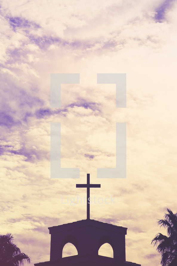 silhouette of a cross on a church roof 