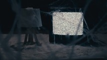 Creepy scene - lamp, spider webs, and tv static