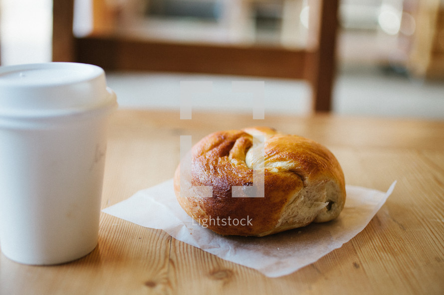 coffee cup and bagel on a napkin 