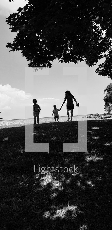 silhouettes of a mother and children on a beach 