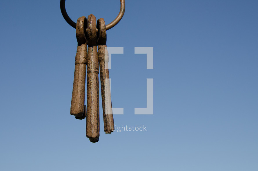 ring of old keys hanging in front of blue sky