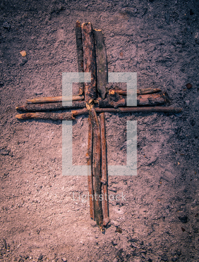 cross made out of sticks in ashes