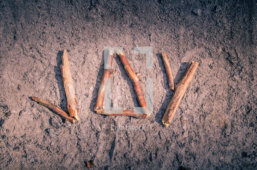 word joy made with sticks in ashes