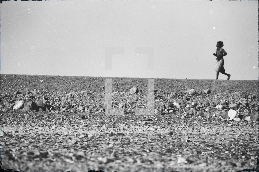 a man running across a desert 