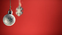 Two silver Christmas ball and snowflake decoration with red background