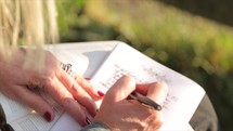 a woman journaling outdoors 