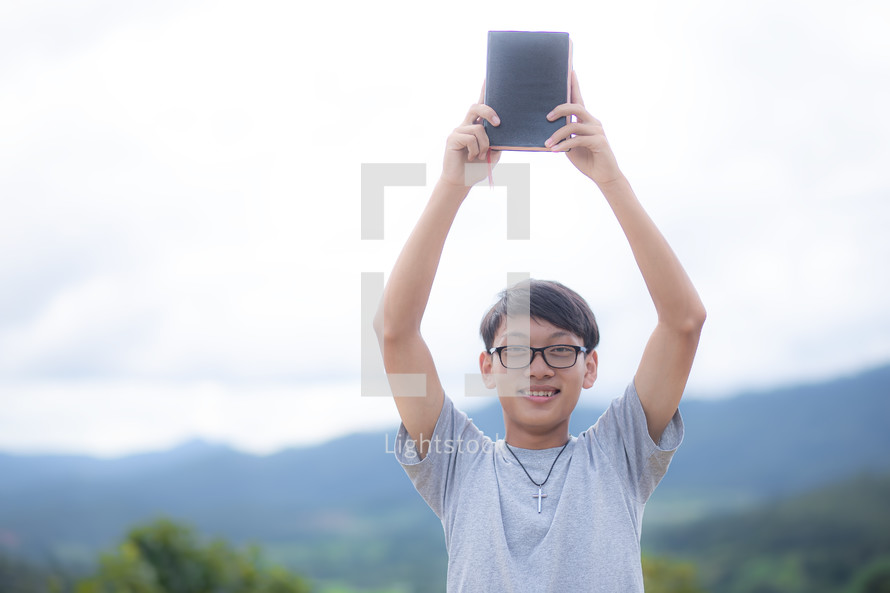 a young man holding up a BIble 