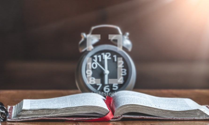 alarm clock and open Bible 