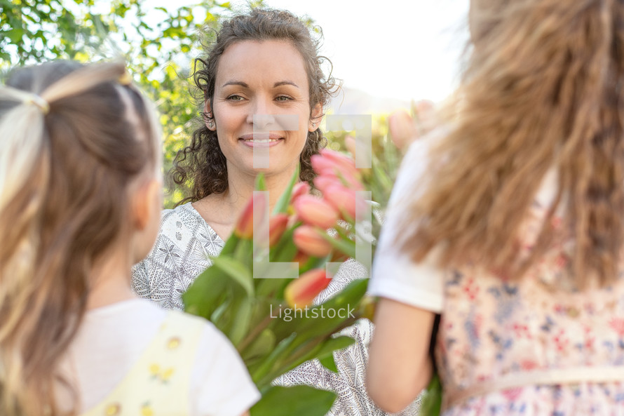 a child giving her mother tulips for mother's day 