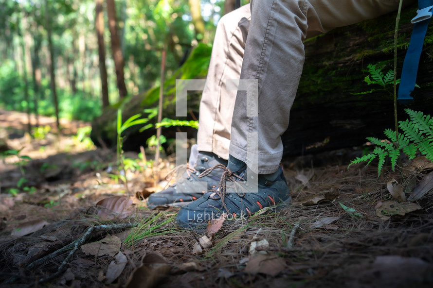 Closeup of male hiker trekking shoes on their adventure in forest.