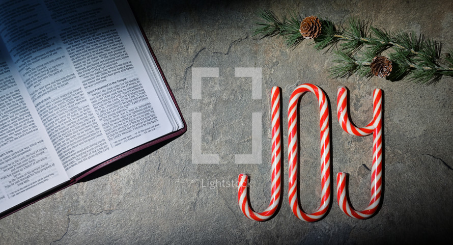 Candy canes in the shape of "joy" next to Bible
