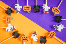 Halloween cocktail sticks, on a purple and orange background.