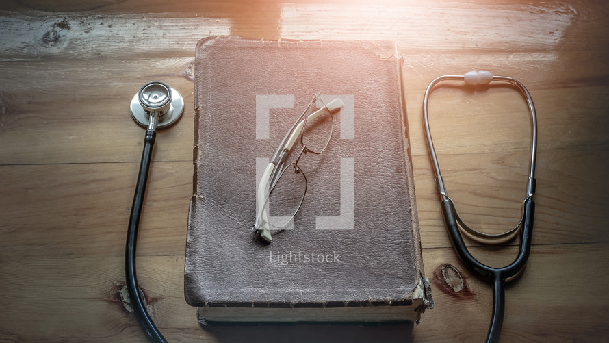 stethoscope and Bible on a wood table 