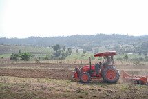 Farmers working a tractor in a field