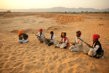 nomads resting in the sand with rifles 