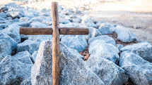 wooden cross on rocks 