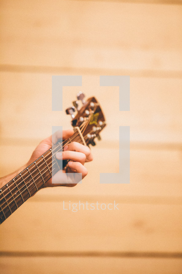 hand around the neck of a guitar 